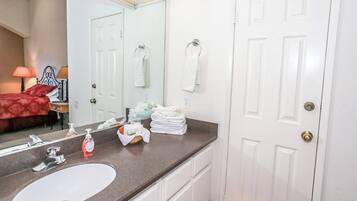 A bathroom with a white sink, mirror, and towel rack.