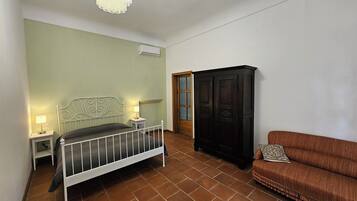 Una camera da letto con un letto, abat-jour, un armadio e un divano.