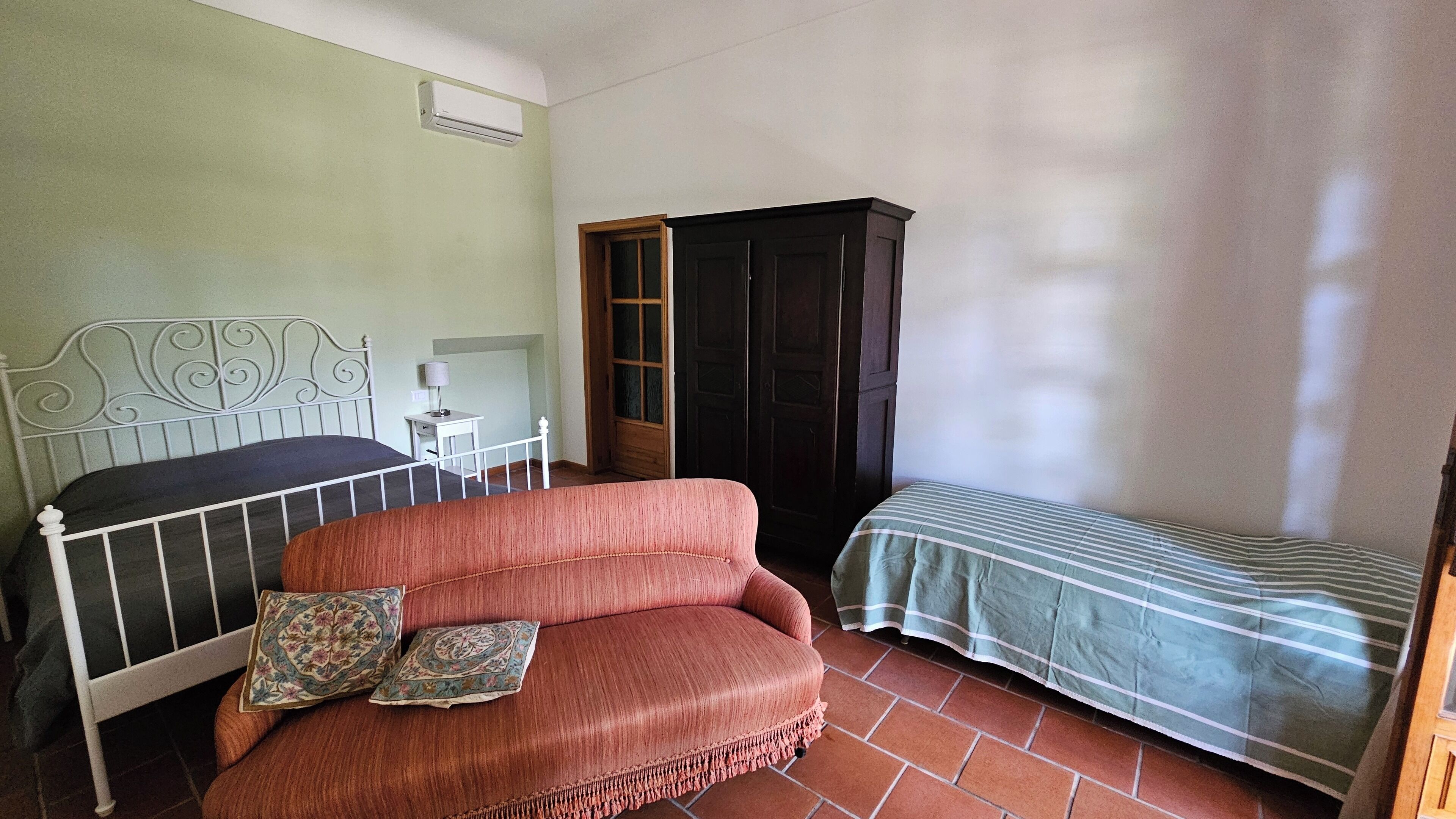 Una camera da letto con un letto, un divano, un tavolino e un armadio.