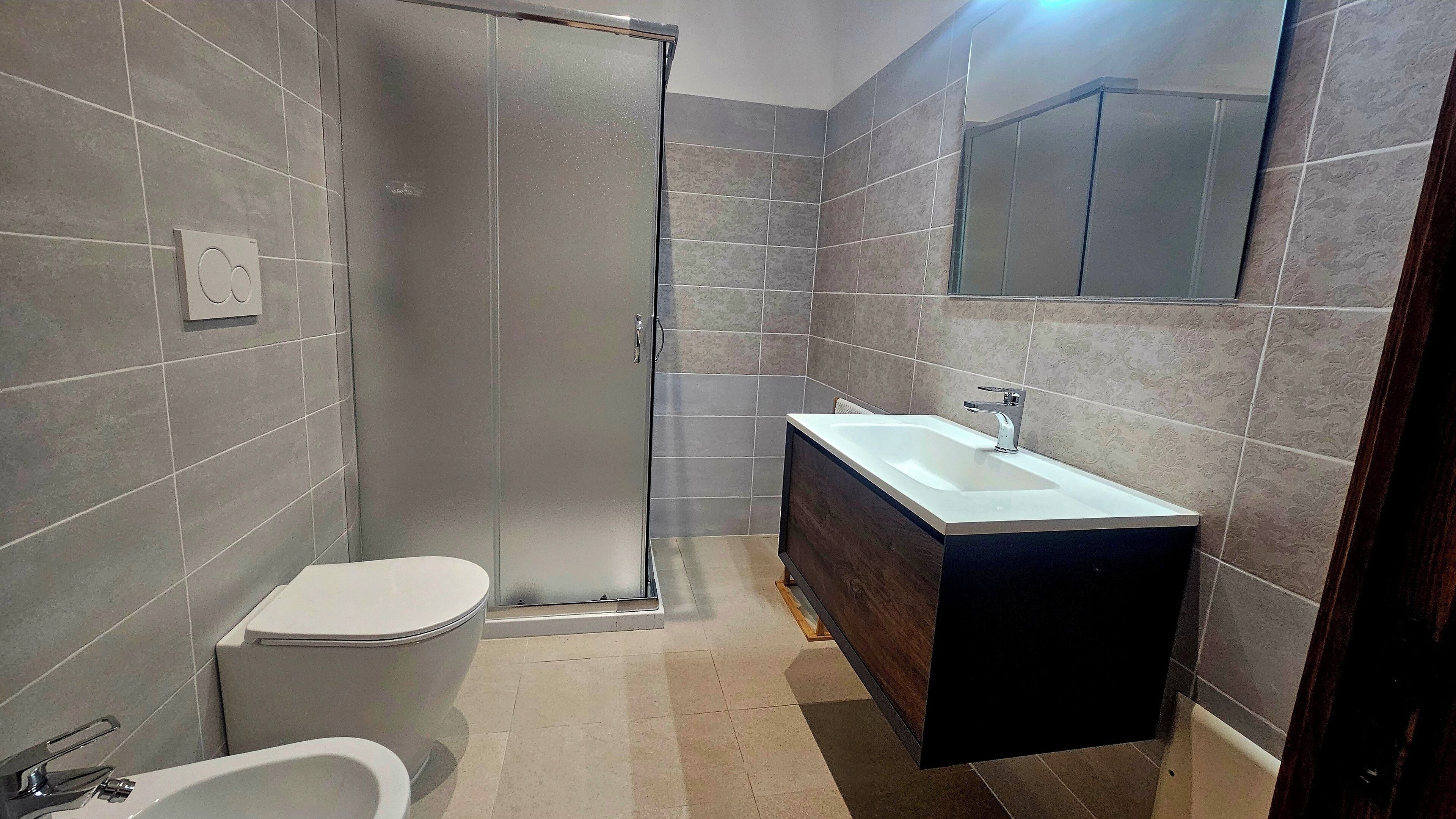 Un baño moderno con ducha, inodoro y tocador.