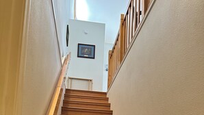 A wooden staircase with a handrail, leading to a landing with a framed picture and a smoke detector. - Charming 3-bedroom house in tranquil Cloudcroft with WiFi (Cloudcroft)
