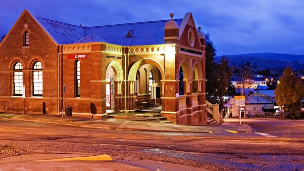 A historic building with a prominent 'Post Office' sign, a brick facade, and arched windows. - Convenient & Cosy Mountain Retreat in Omeo. (Omeo)