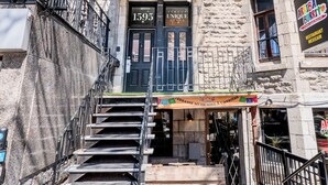 Un edificio con fachada de piedra, una puerta negra con el número 1595 y una escalera que lleva a la entrada.