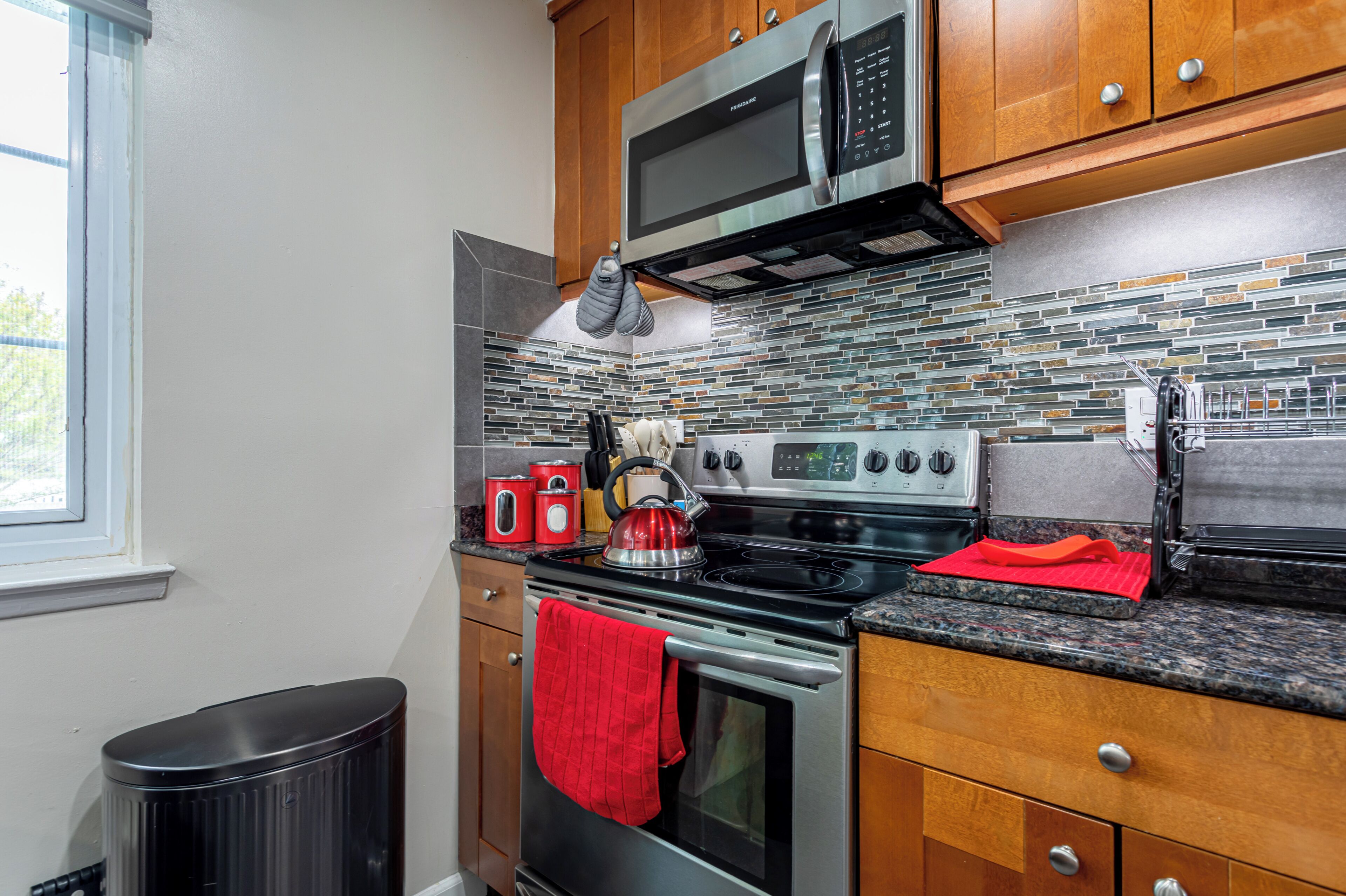 A modern kitchen with stainless steel appliances, a microwave, oven, and a stove.
