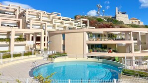 A modern hotel with a swimming pool, multiple balconies, and a view of a historic building in the background. - Spacious 80m² apartment with pool and sea view in Sète (Sète)