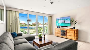 A modern living room with a sofa, a coffee table, and a television on a wooden cabinet.