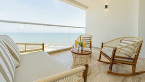 A balcony with a view of the ocean, featuring wicker furniture and a table with drinks. - Seaside Serenity and Style (Cartagena de Indias)