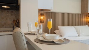A modern hotel room with a kitchenette, a dining area, and a bed with white bedding. - Seaside Serenity and Style (Cartagena de Indias)