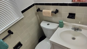 Ein Badezimmer mit Toilette, Waschbecken und Handtuchhalter.