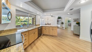 A modern kitchen with wooden cabinets, granite countertops, and a built-in dishwasher.
