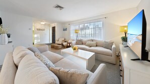 A modern living room with a sofa set, a coffee table, and a TV.