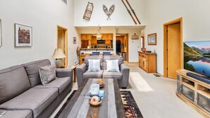 A modern living room with a sofa, coffee table, and a TV on a wooden stand. - Lakeside Comfort  • Walk to Lake Dillon • Minutes to Ski Resorts (Frisco)