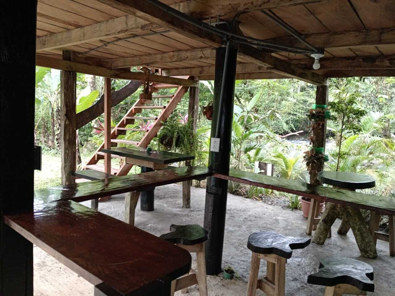 Una estructura de madera al aire libre con mesas de picnic y una escalera que conduce a un nivel superior.