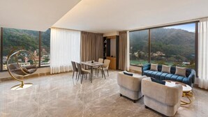 A spacious living room with a dining area, a blue sofa, and a hanging chair. - Zana By The Ganges, Rishikesh (Narendranagar)