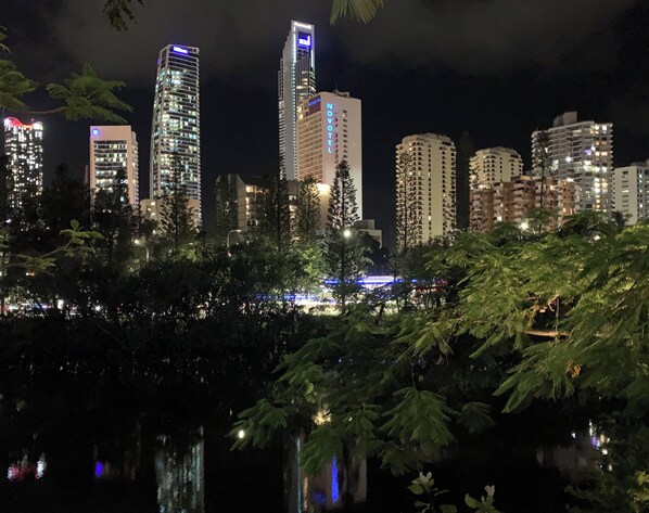 A nighttime cityscape with high-rise buildings, including a Novotel hotel, and a body of water reflecting the lights. - Serenity in Surfers Paradise (Surfers Paradise)