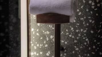 A bathroom with a mirror, a towel, and a shaving kit hanging on a towel rack.
