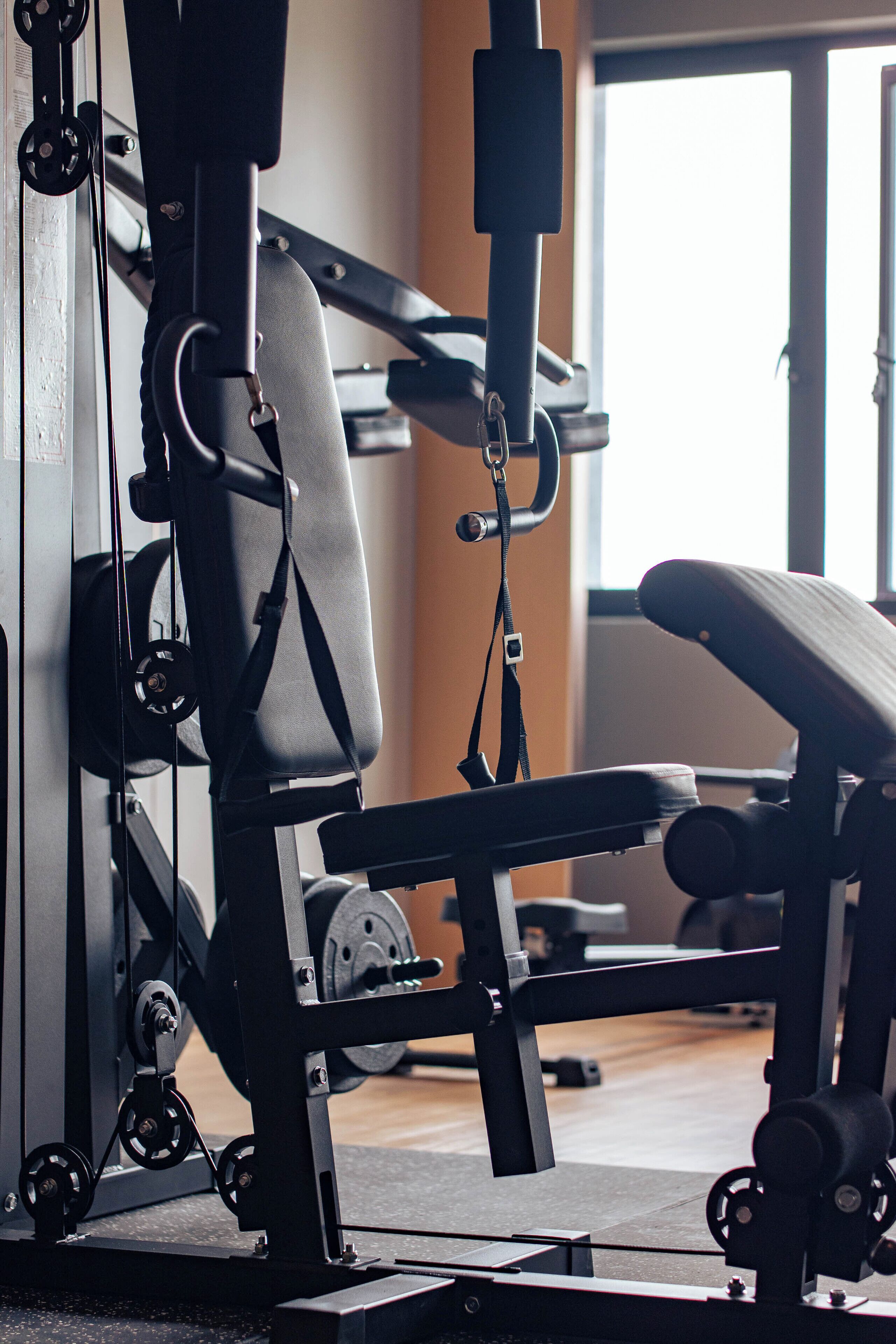 Un gimnasio con equipo de ejercicio, incluyendo una banca y máquinas de pesas.
