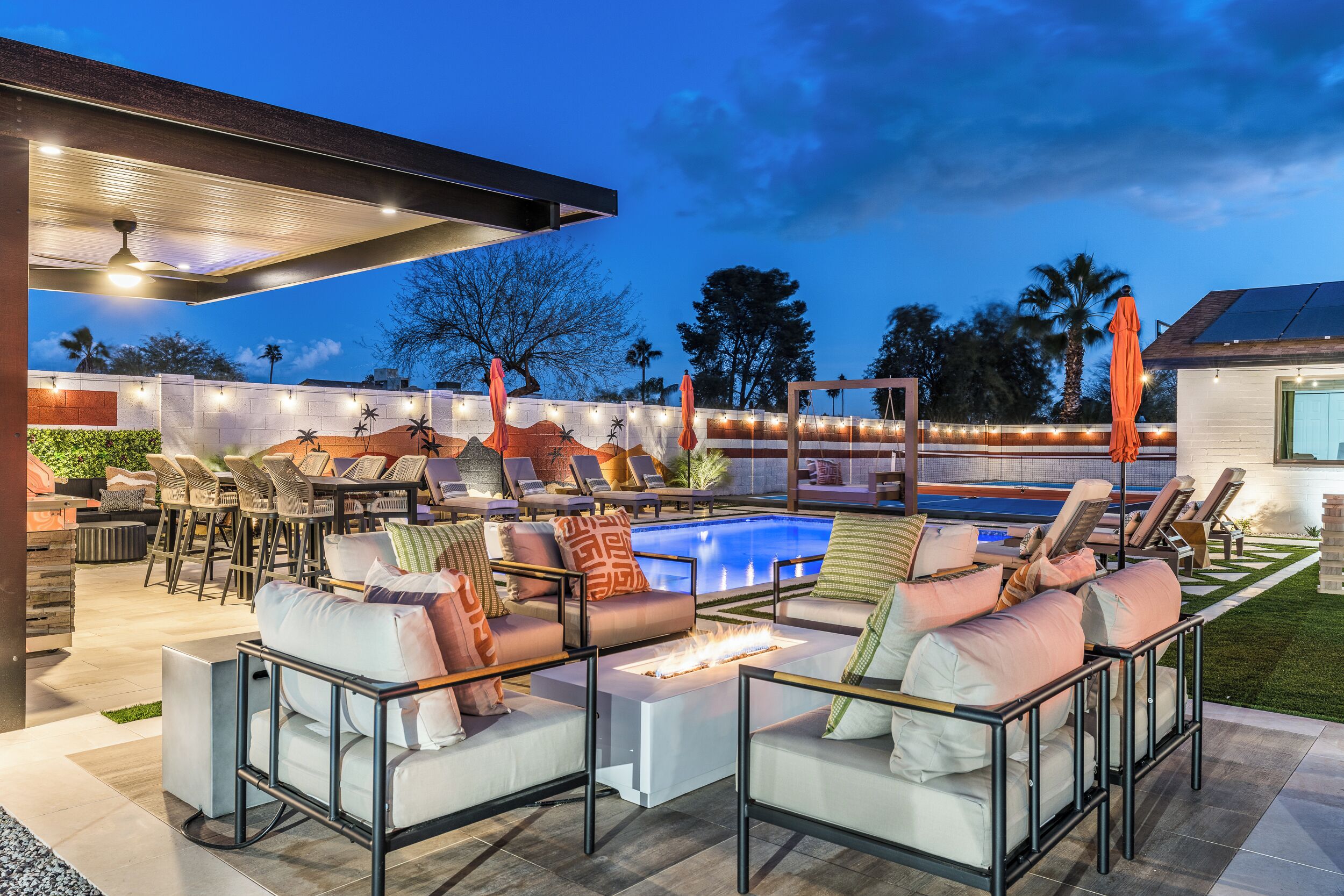 An outdoor lounge area with a pool, seating, and ambient lighting.