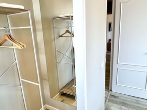 A walk-in closet with metal shelving and wooden hangers.