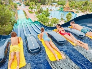 A water park with a large water slide, multiple water slides, and a pool area.