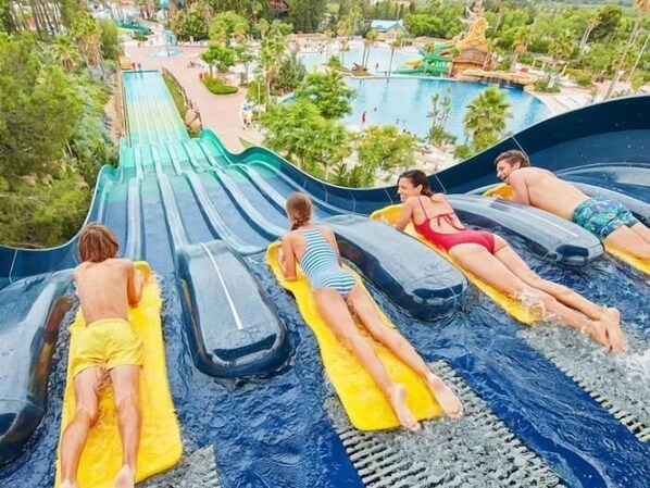 A water park with a large water slide, multiple water slides, and a pool area.
