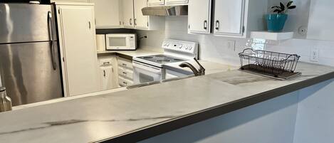 Een microgolfoven, een oven, een kookplaat, een vaatwasser