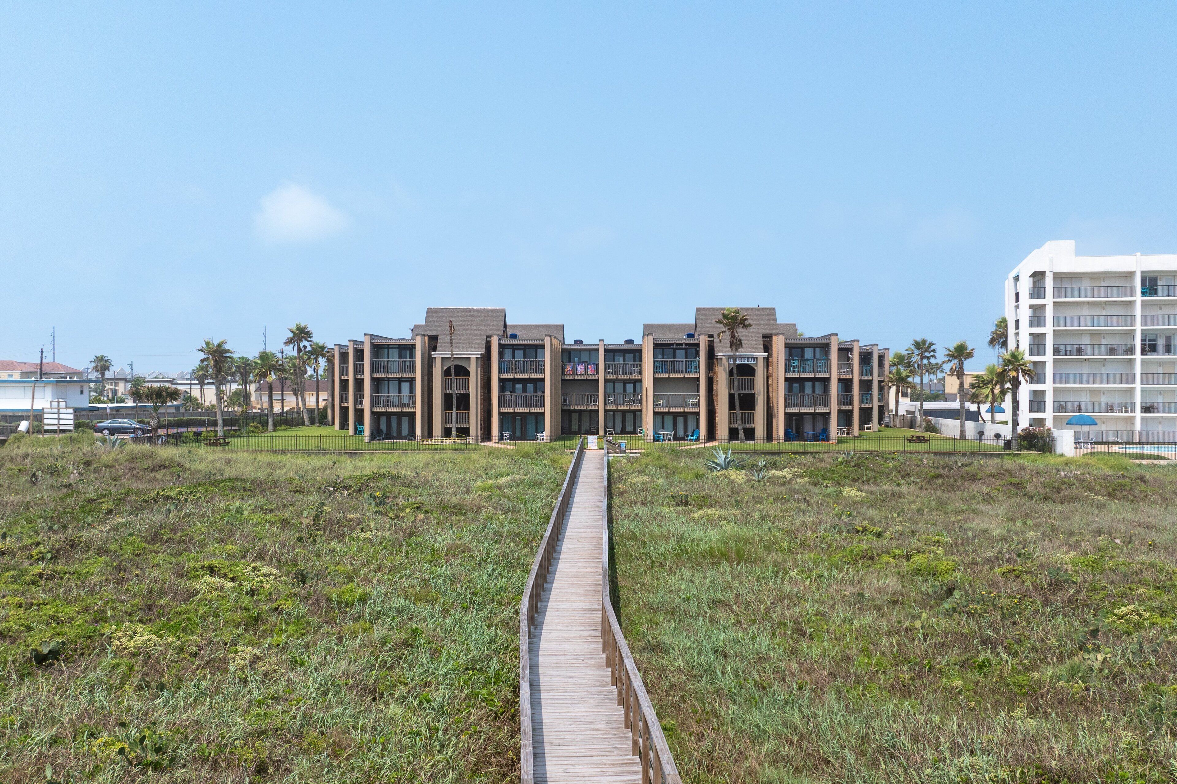 Un bâtiment moderne doté d’une cour intérieure, entourée d’une promenade en bois.
