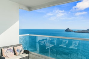 A balcony with a glass railing overlooking a clear blue sea and distant islands. - Beautiful Long stay Unit with Premium Ameneties (Mazatlan)