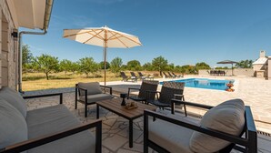 Un espace extérieur aménagé avec une piscine, des chaises longues et des parasols.