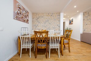 Un espace repas avec un mur en briques, une table à manger en bois et des chaises.