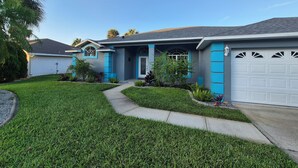 A residential house with a well-maintained lawn, a driveway, and a garage.
