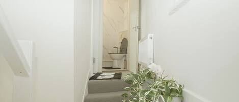 A staircase leading to a bathroom with a toilet and a sink.