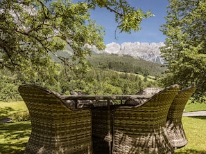 Sillas de mimbre con vistas a un paisaje montañoso.