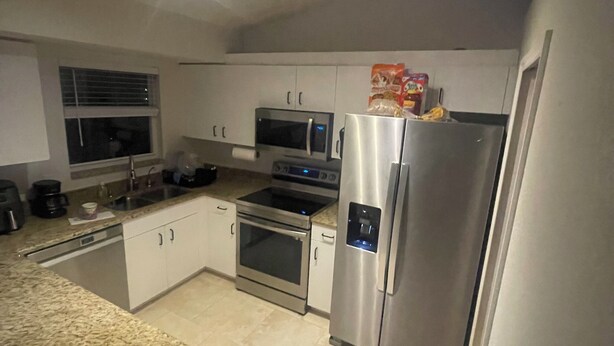 A modern kitchen with stainless steel appliances, a dishwasher, and a microwave.