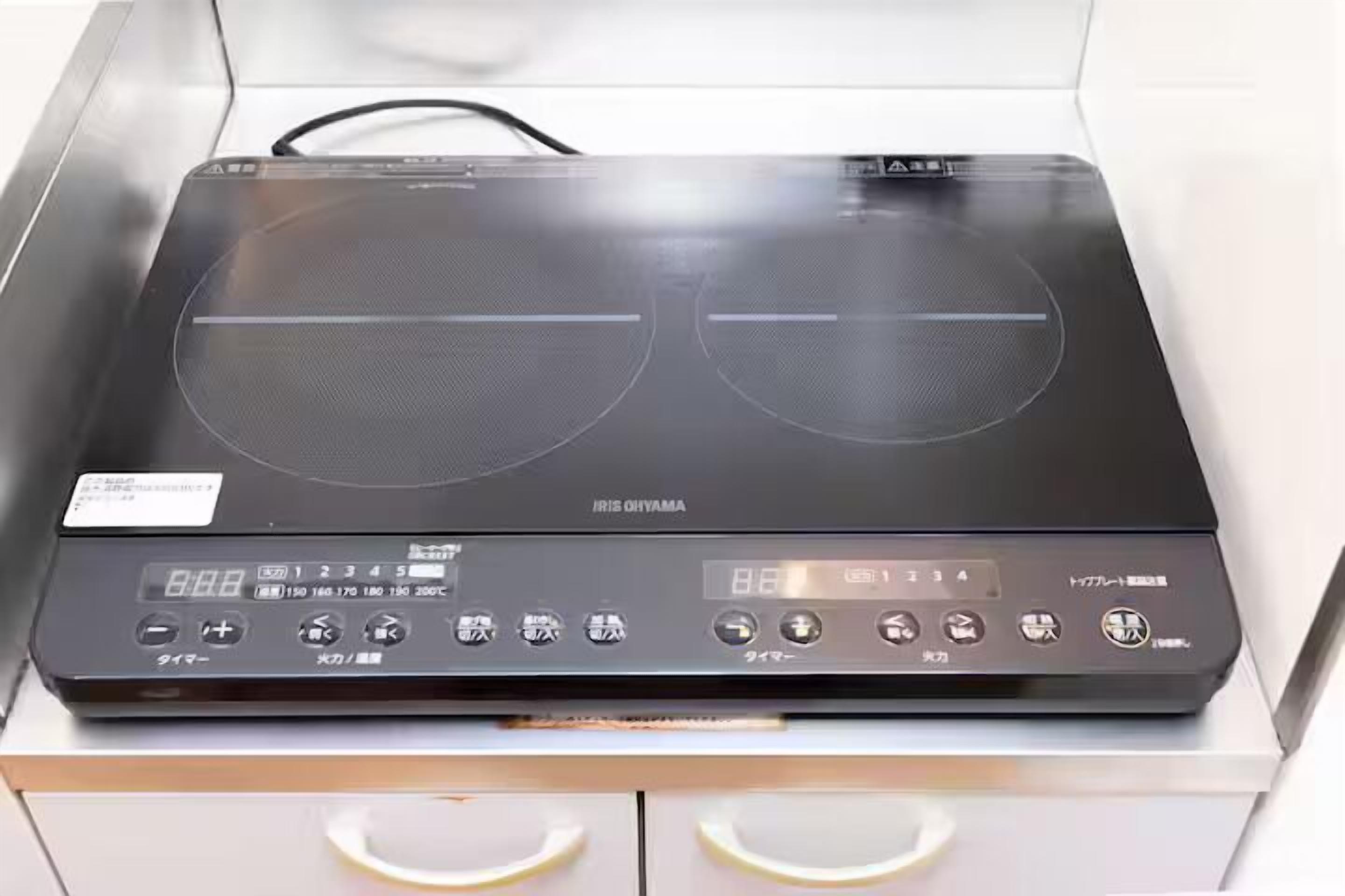 A kitchen with an induction cooktop and a digital control panel.
