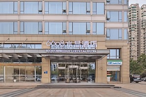 A modern hotel with a clear entrance, large windows, and a visible FamilyMart store. - Hangzhou West Lake 6698 Crystal Hotel (Hangzhou)