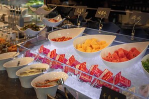 A buffet with various food items displayed in bowls on ice, with utensils and condiments nearby. - Hangzhou West Lake 6698 Crystal Hotel (Hangzhou)