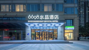 Das Äußere des Sixixnineight Crystal Hotels mit einem markanten Eingang und einem FamilyMart-Geschäft daneben.