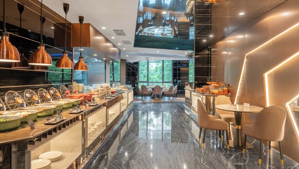 Eine moderne Hotelhalle mit Marmorboden, einem Buffetbereich und Sitzgelegenheiten.