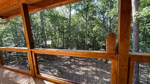A wooden deck with a view of a forest.