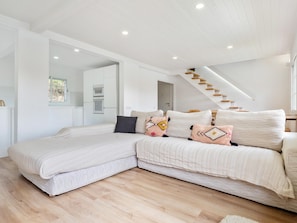 A modern bedroom with a large bed, a staircase, and a view of the kitchen. - Large outdoor area, private pool and have fun (Sant Cebrià de Vallalta)
