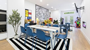 A modern kitchen with a dining area, featuring a striped rug, blue chairs, and a large abstract painting on the wall. - Spacious 4-bedroom house Game Room & Spa in fantastic Dallas 11 (Dallas)
