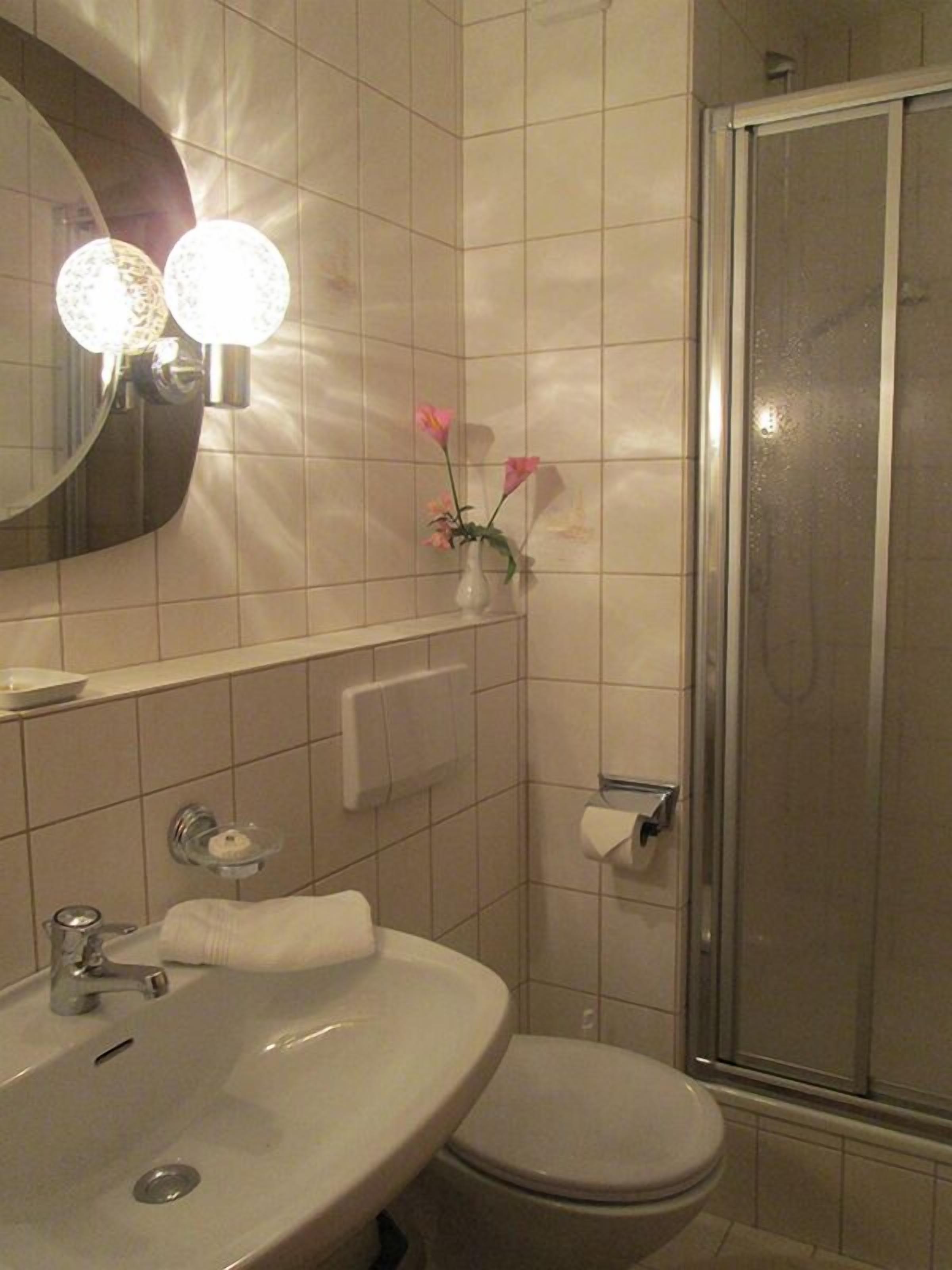 A bathroom with a sink, toilet, and a shower.