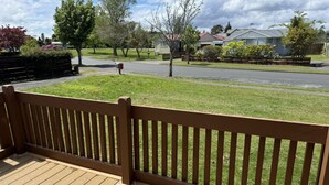 A wooden deck with a fence overlooking a residential street. - 2 Double 1 Single 1 Sofa Beds Studio A (Rotorua)