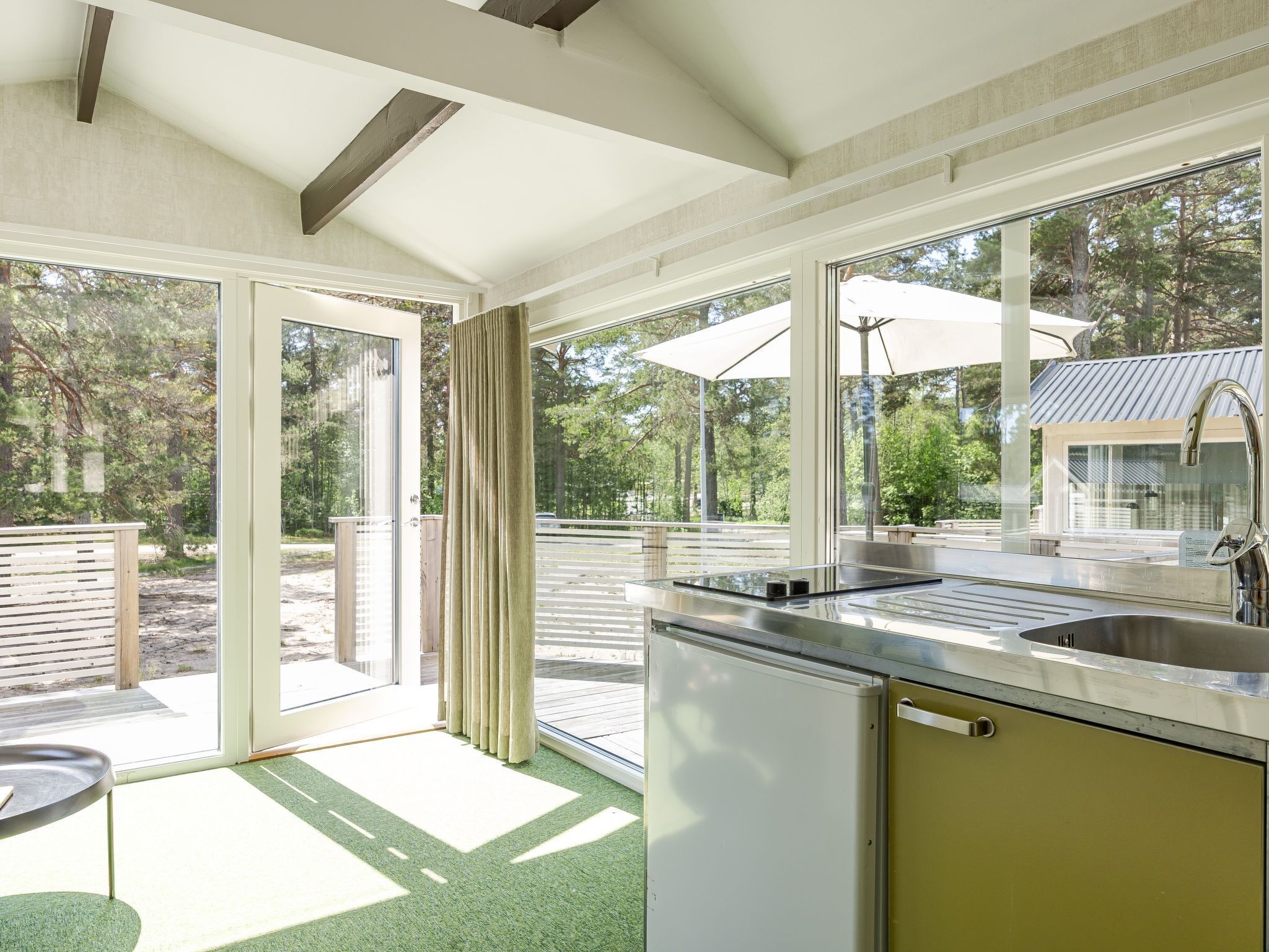 A modern kitchen with a large window, a sink, and a refrigerator.