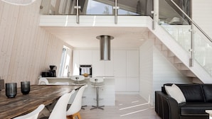 A modern interior with a dining area, kitchen, and staircase. - Lagunen Villa 3 by Interhome (Hölick)