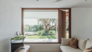 Ein modernes Wohnzimmer mit großem Fenster, einer Couch und einem Holztisch.