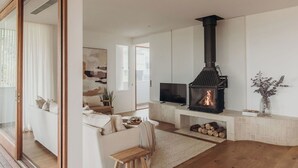 Ein Wohnzimmer mit Kamin, einer Couch, einem Fernseher und einem großen Spiegel.