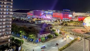 A nighttime cityscape with a prominent building featuring a large, illuminated globe sculpture. - Cozy 1-bedroom condo in beautiful Pasay City with WiFi, AC (Pasay city)