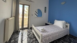 Un dormitorio con cama, mesita de noche, espejo y radiador.